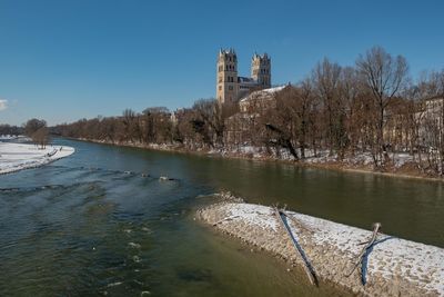 View of building by river against clear sky