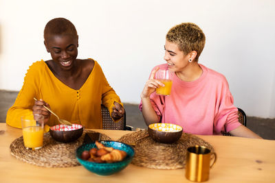 Portrait of young woman having food at home