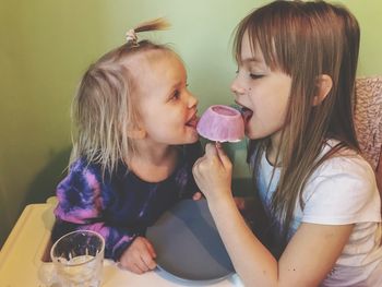 Sisters eating ice cream while sitting at home