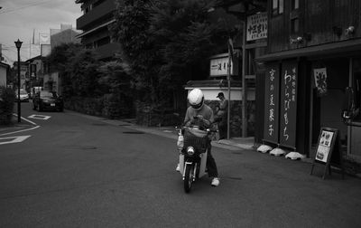 Rear view of man riding bicycle on street