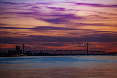 View of bridge over sea against sunset sky