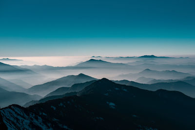 Scenic view of mountains against blue sky