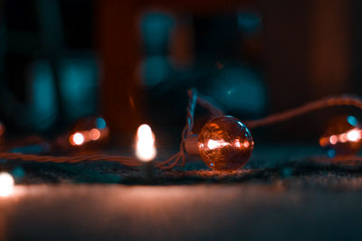 Close-up of illuminated string light on table in darkroom