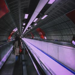 People on moving walkway in building