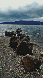 Rocks on beach against sky