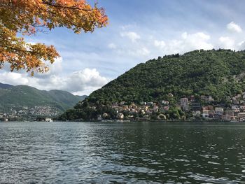 Scenic view of town by mountains against sky