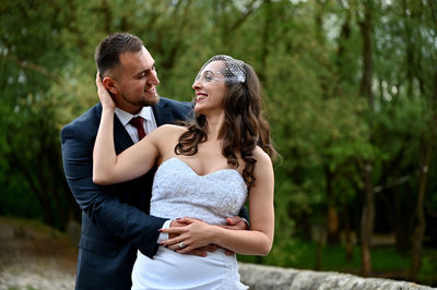 Young couple kissing against trees