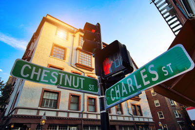 Low angle view of information sign against sky in city