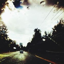 Cars on road against sky in city