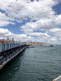 Scenic view of river by buildings against sky