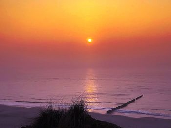 Scenic view of sea against romantic sky at sunset