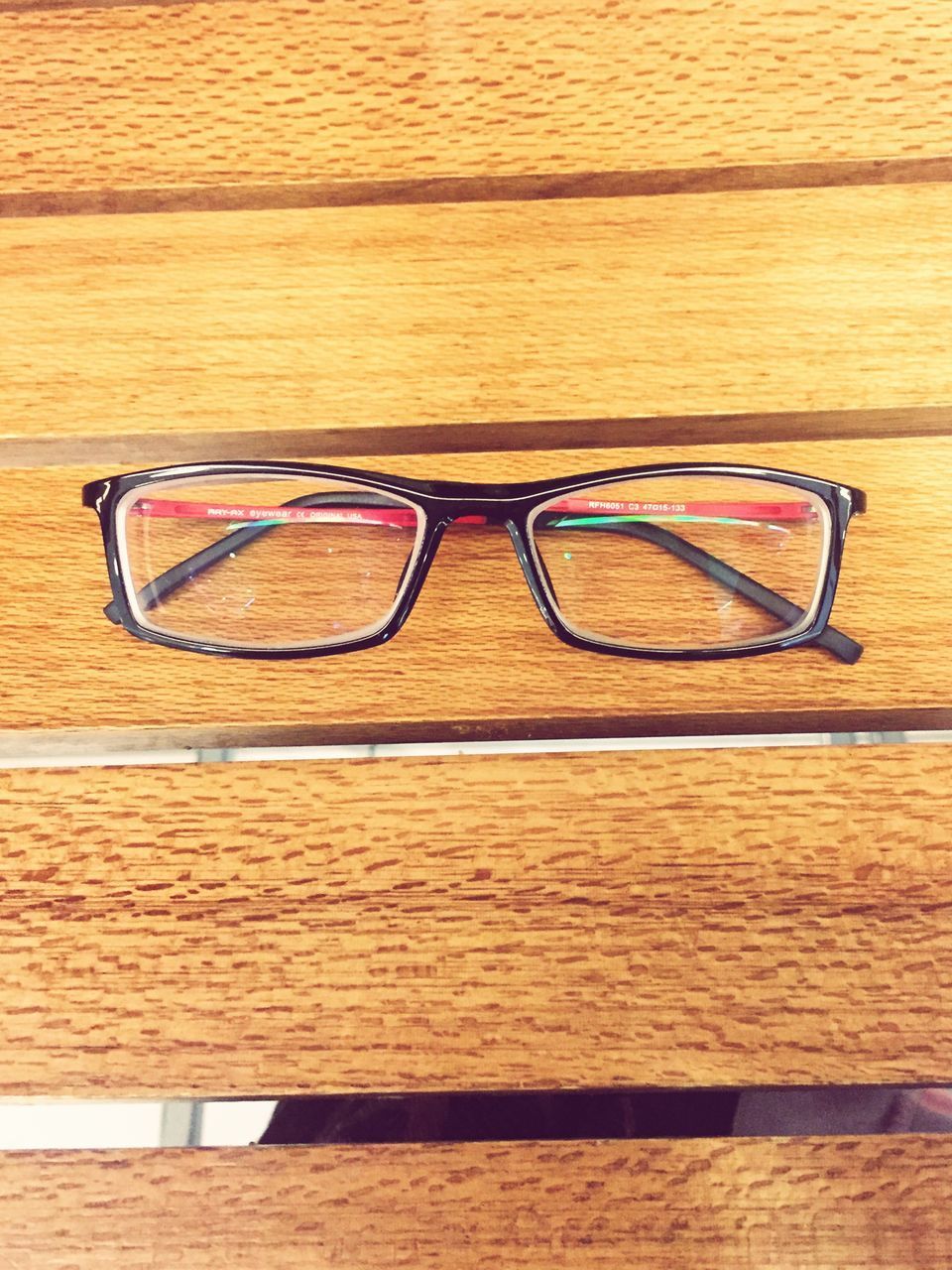 CLOSE-UP OF EYEGLASSES AND TABLE