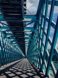 Empty footbridge against sky