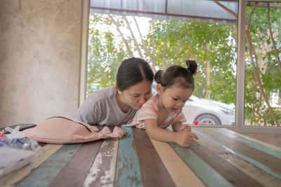 Friends looking at camera while sitting on floor