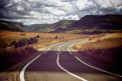 Road passing through mountains against sky