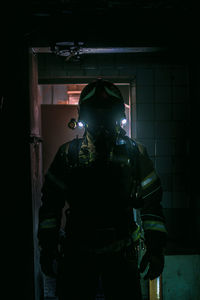 Portrait of person standing at illuminated entrance