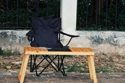 Empty chair and table against wall