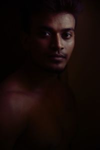 Close-up portrait of young man against black background