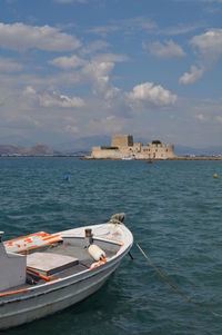 Boats moored in sea against buildings