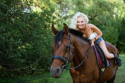 Beautiful woman with horse in summer park