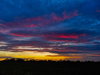 Scenic view of dramatic sky over silhouette landscape