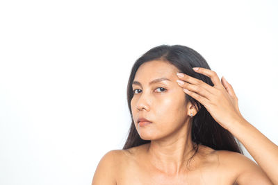 Portrait of shirtless young woman against white background