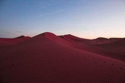 Scenic view of desert against sky during sunset