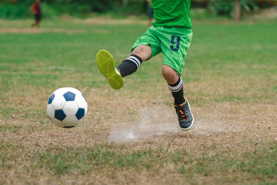 Low section of man playing soccer on field