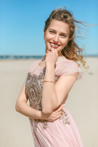 Portrait of a smiling young woman standing on beach