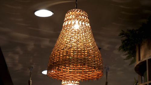 Low angle view of illuminated pendant lights hanging from ceiling