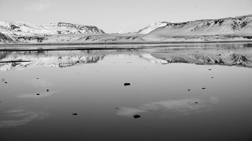 Scenic view of lake and snowcapped mountains against sky