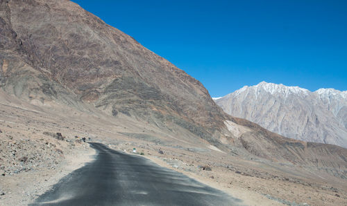 Scenic view of snowcapped mountains against clear blue sky