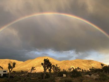 Scenic view of rainbow over mountain against sky