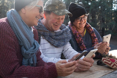 Senior man with women using phones at forest