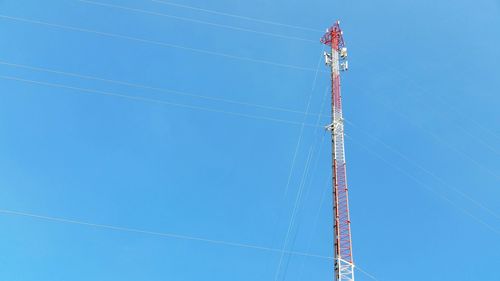 Low angle view of crane against clear blue sky