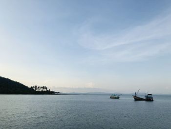 Boats sailing in sea against sky