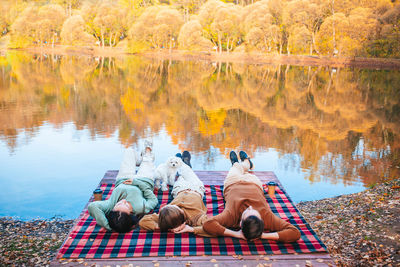 People sitting by lake