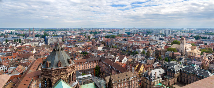 High angle view of buildings in city against cloudy sky