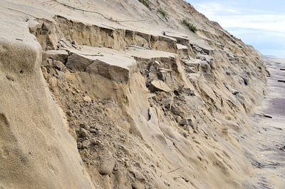 Rock formation on beach against sky