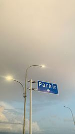 Low angle view of road sign against sky