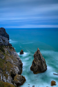 Rocks on sea shore against sky