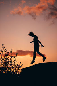 Silhouette man standing against orange sky