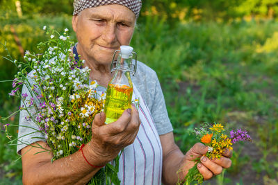 Cropped hand of woman holding flowers