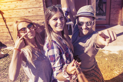 Portrait of smiling friends sitting at beach