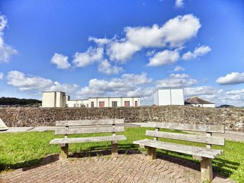 Built structure on landscape against cloudy sky