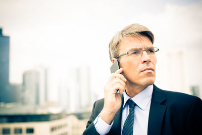Close-up of man using mobile phone in city