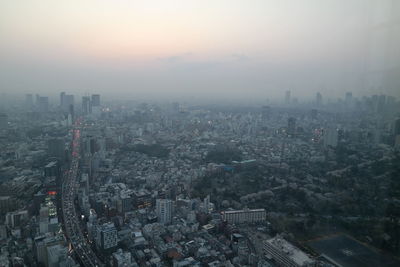 High angle view of city buildings against sky during sunset