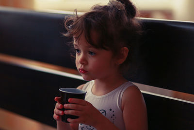 Close-up of girl having drink at home