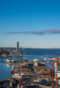 High angle view of city by sea against sky