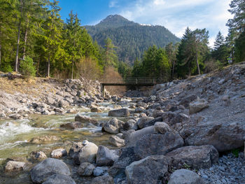 Scenic view of river by mountains against sky